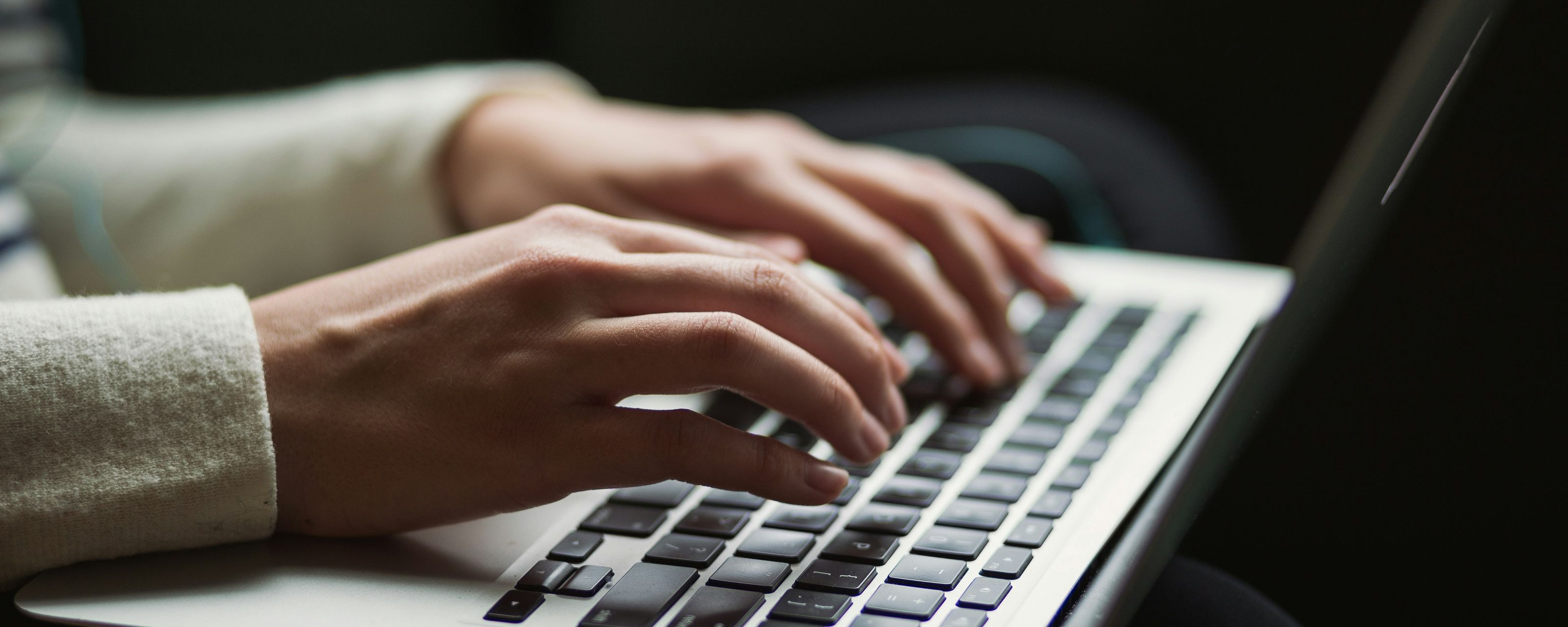 Hender ved tastaturet på en laptop