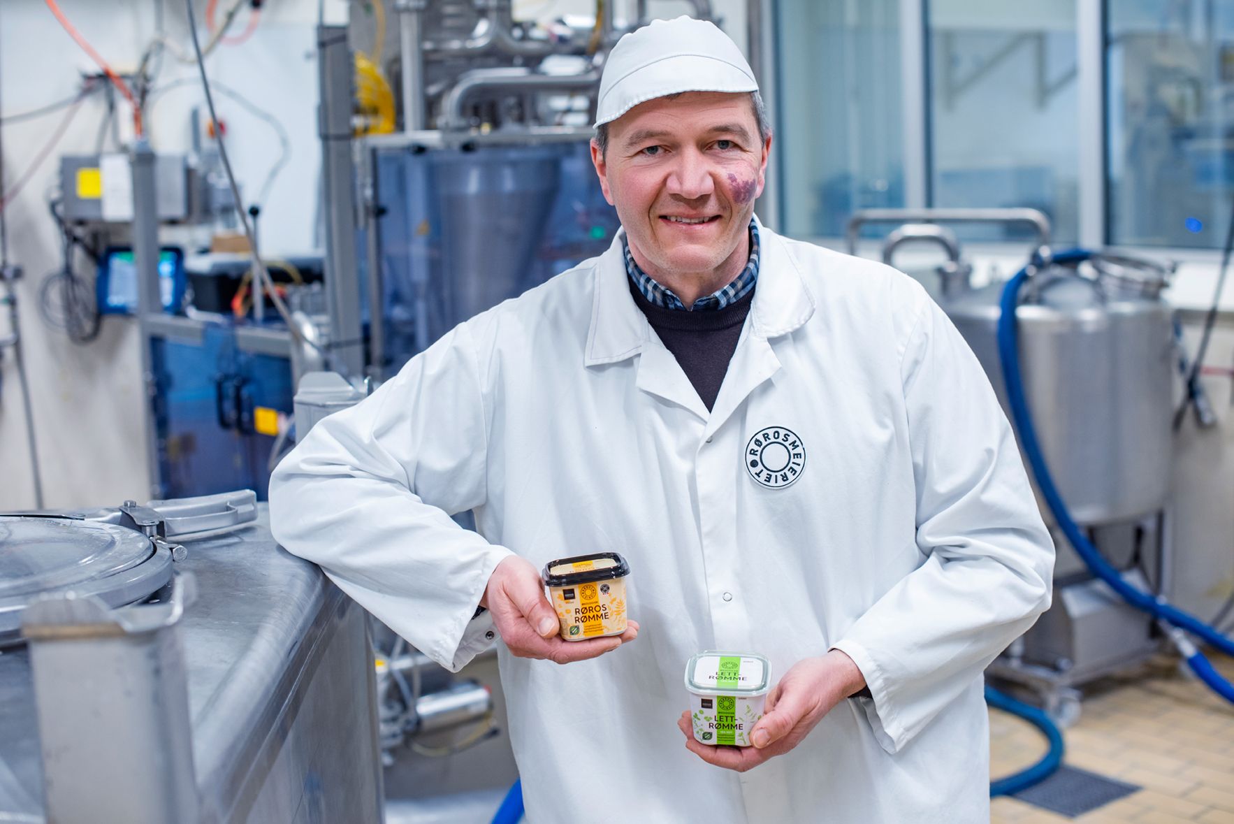  Meieribestyrer ved Rørosmeieriet med et par rømmebokser i hånda.