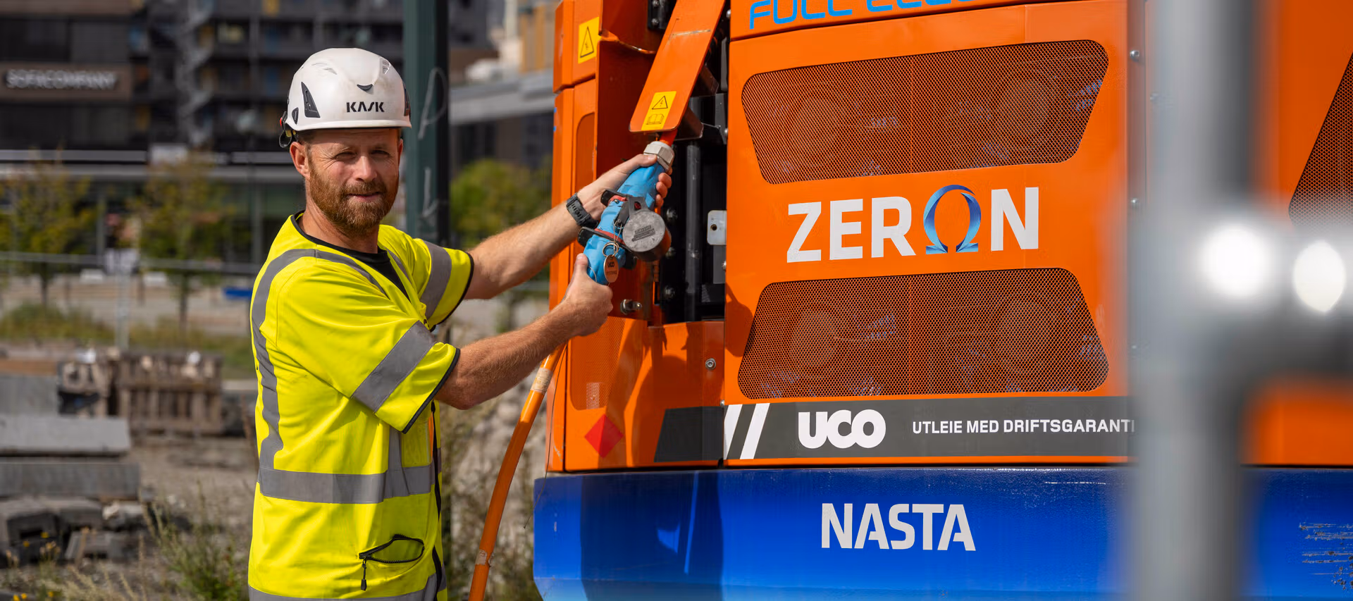 Bygningsarbeidere lader elektrisk anleggsmaskin.