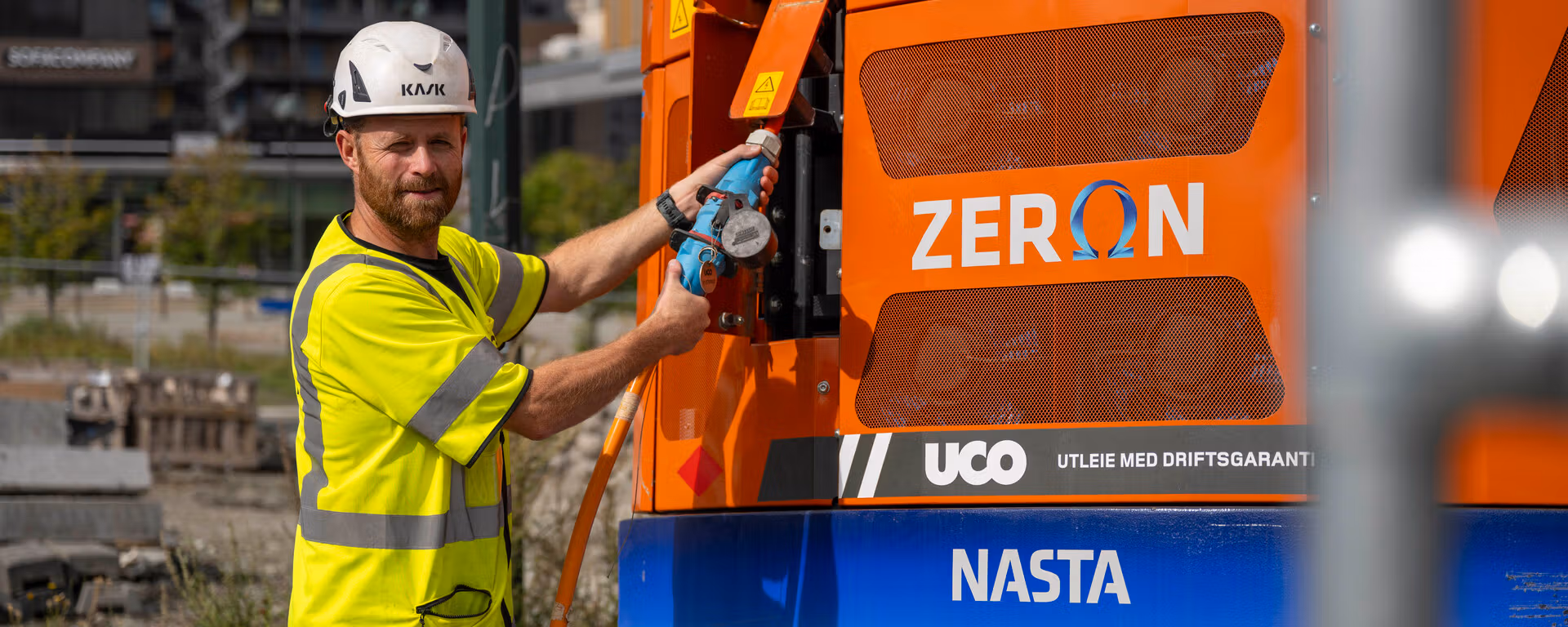 Bygningsarbeidere lader elektrisk anleggsmaskin.