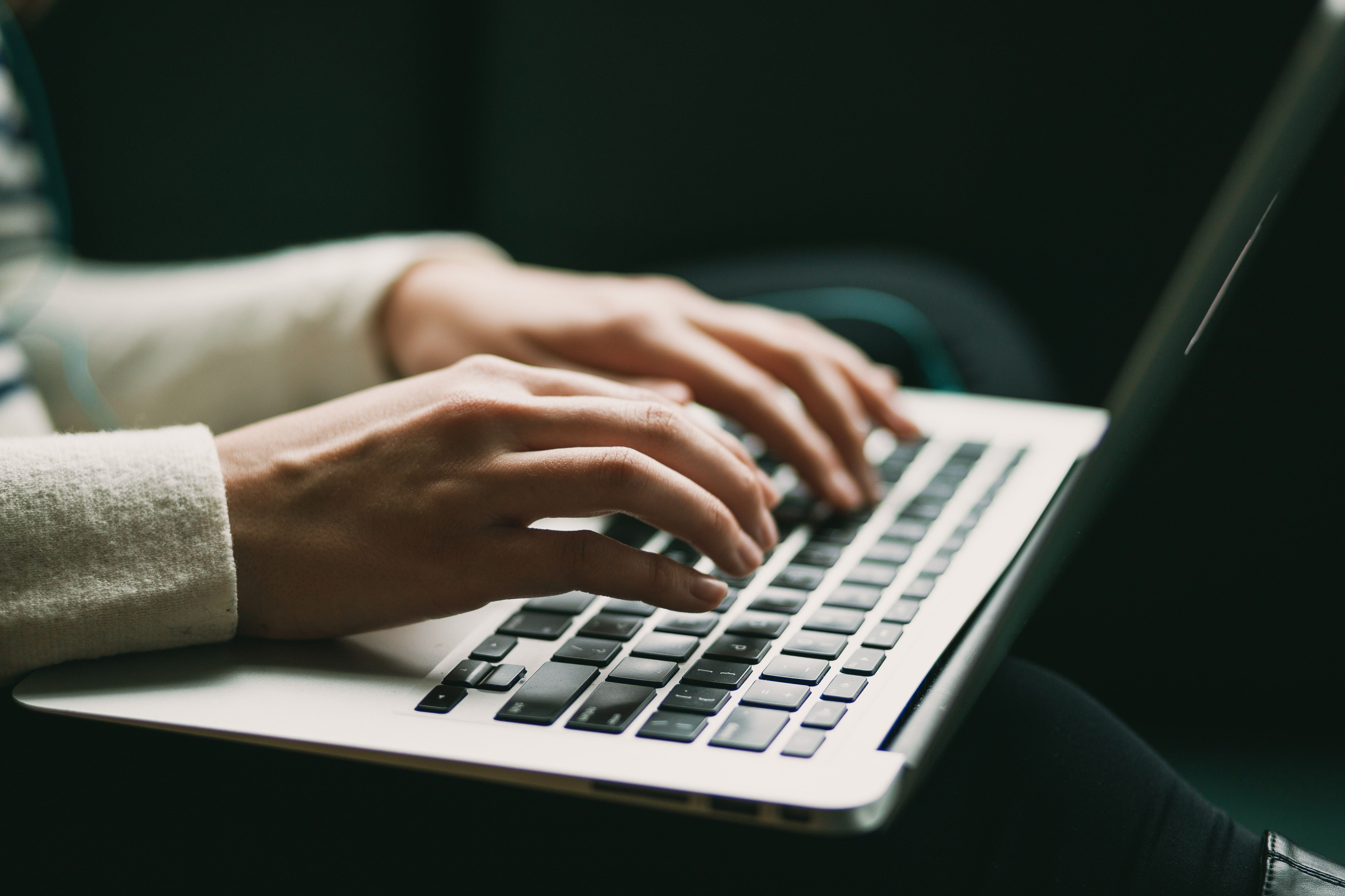 Hender ved tastaturet på en laptop