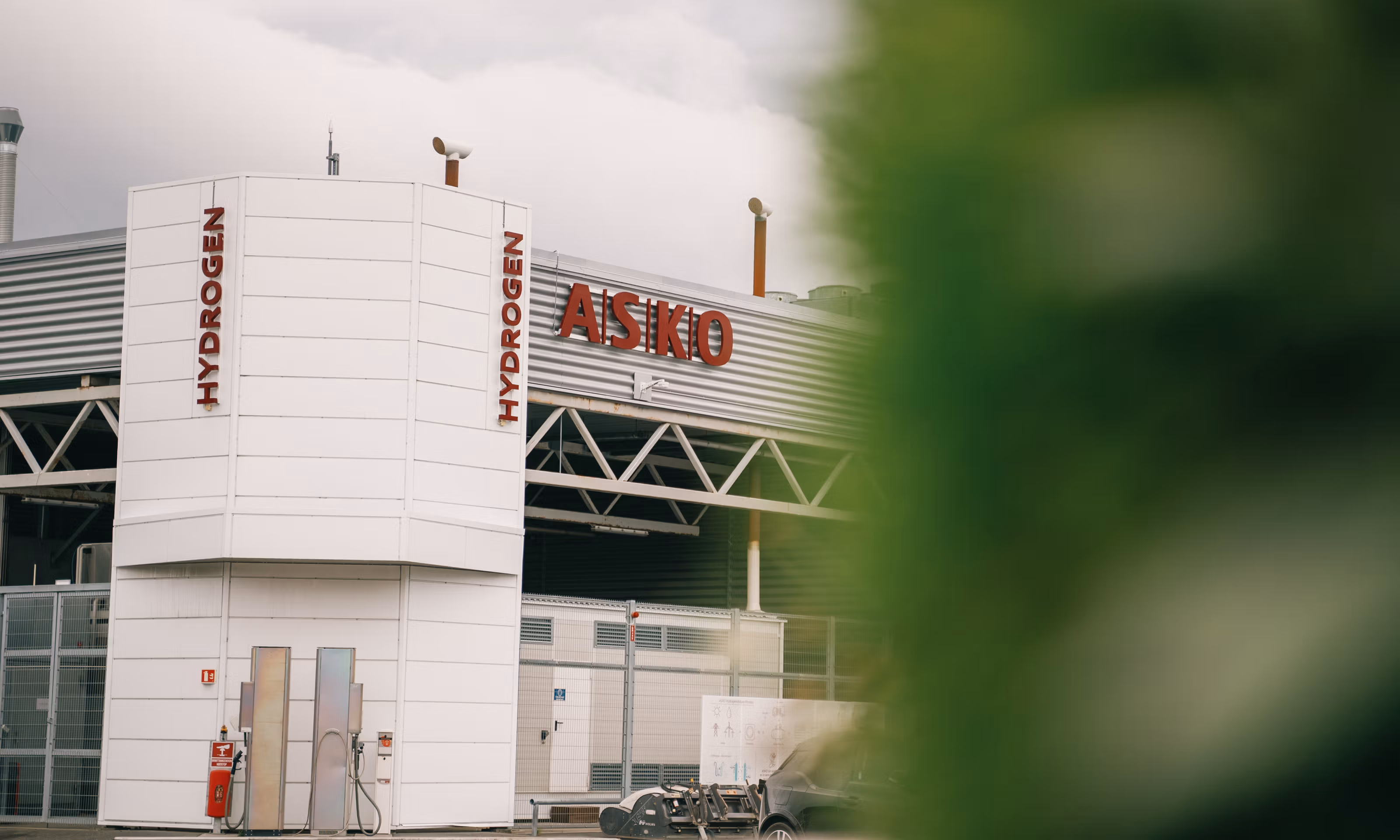 En ladestasjon for hydrogen med uskarp, grønn forgrunn.