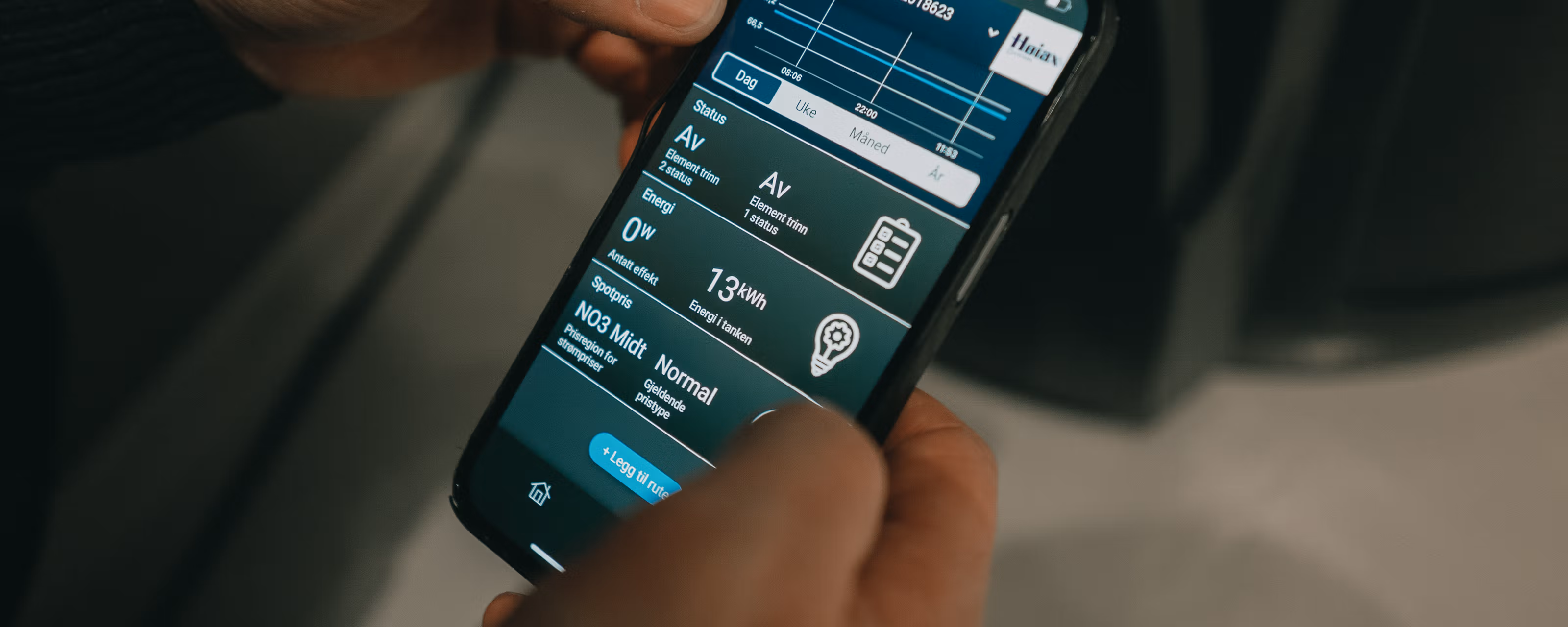 Nærbilde av hender som holder mobilen som viser strømforbruk.