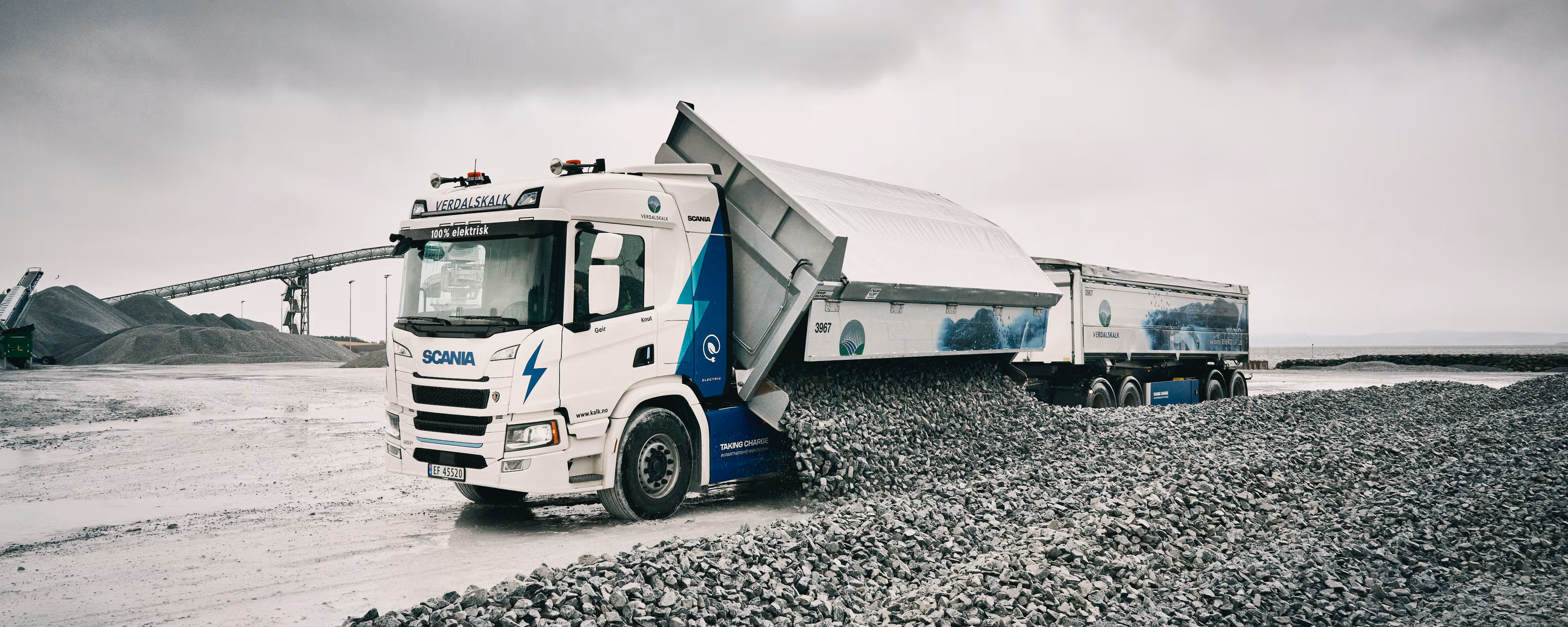 En lastebil som laster av stein.