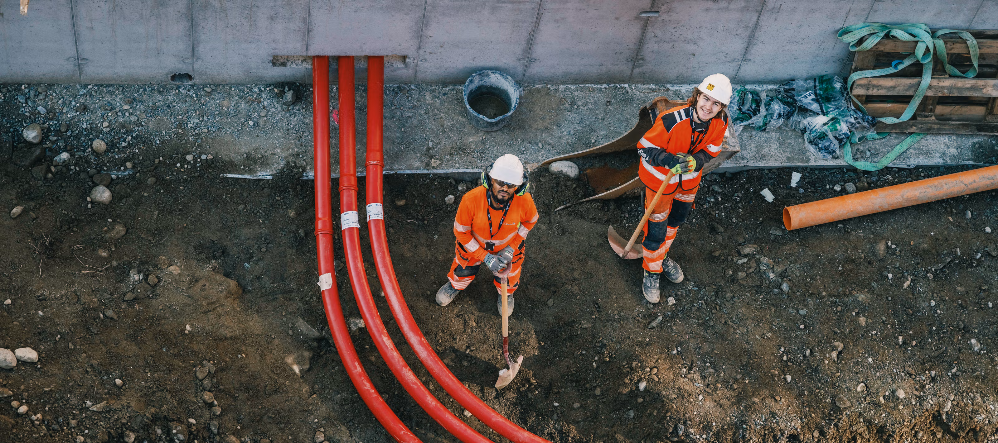 Bygningsarbeidere titter opp mot fotografen som står på en stillas.