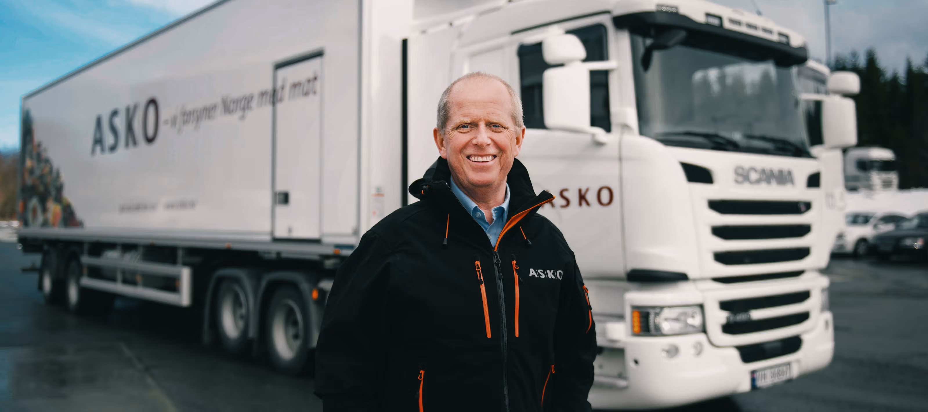 Mann smiler foran en elektrisk lastebil.