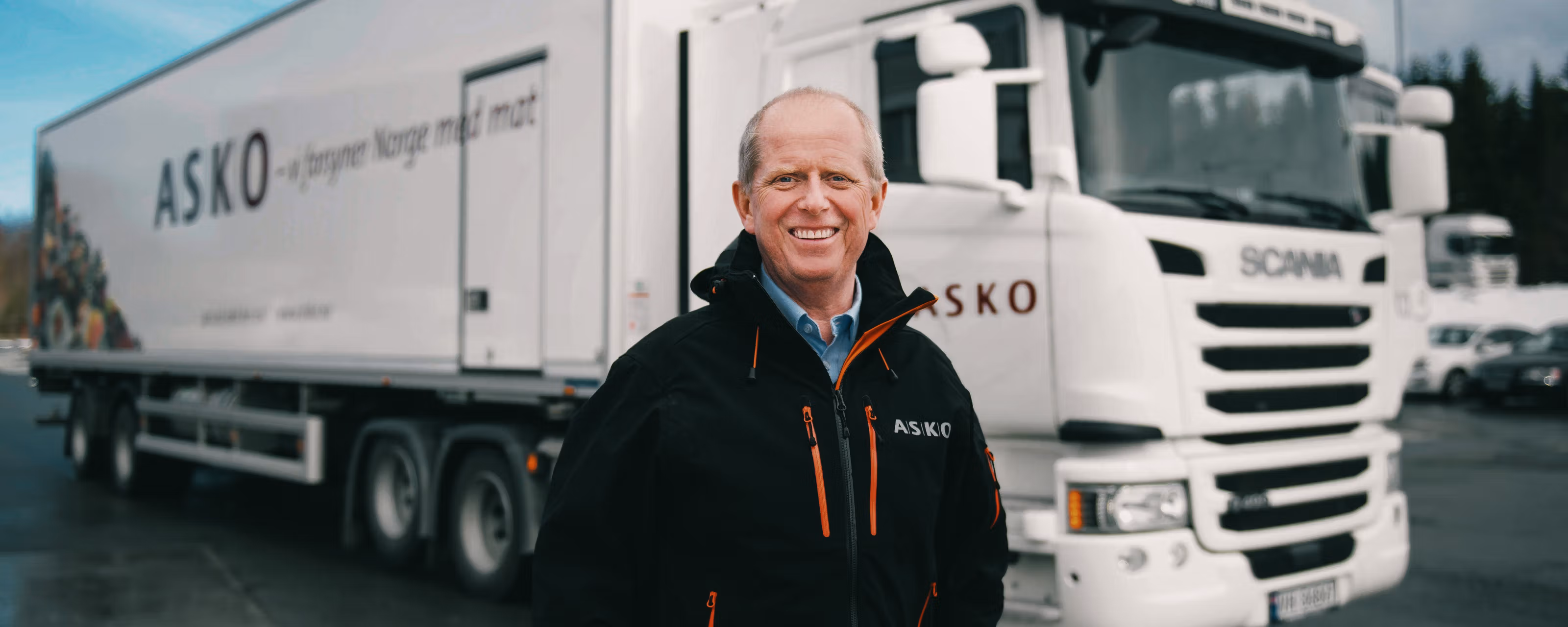 Mann smiler foran en elektrisk lastebil.