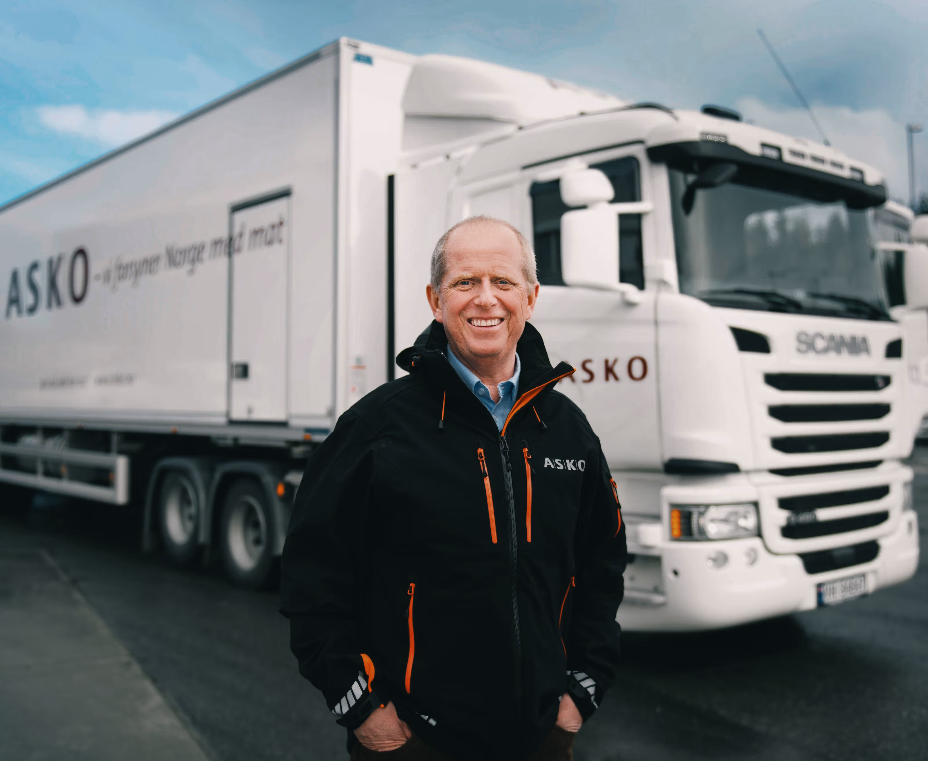 Mann smiler foran en elektrisk lastebil.