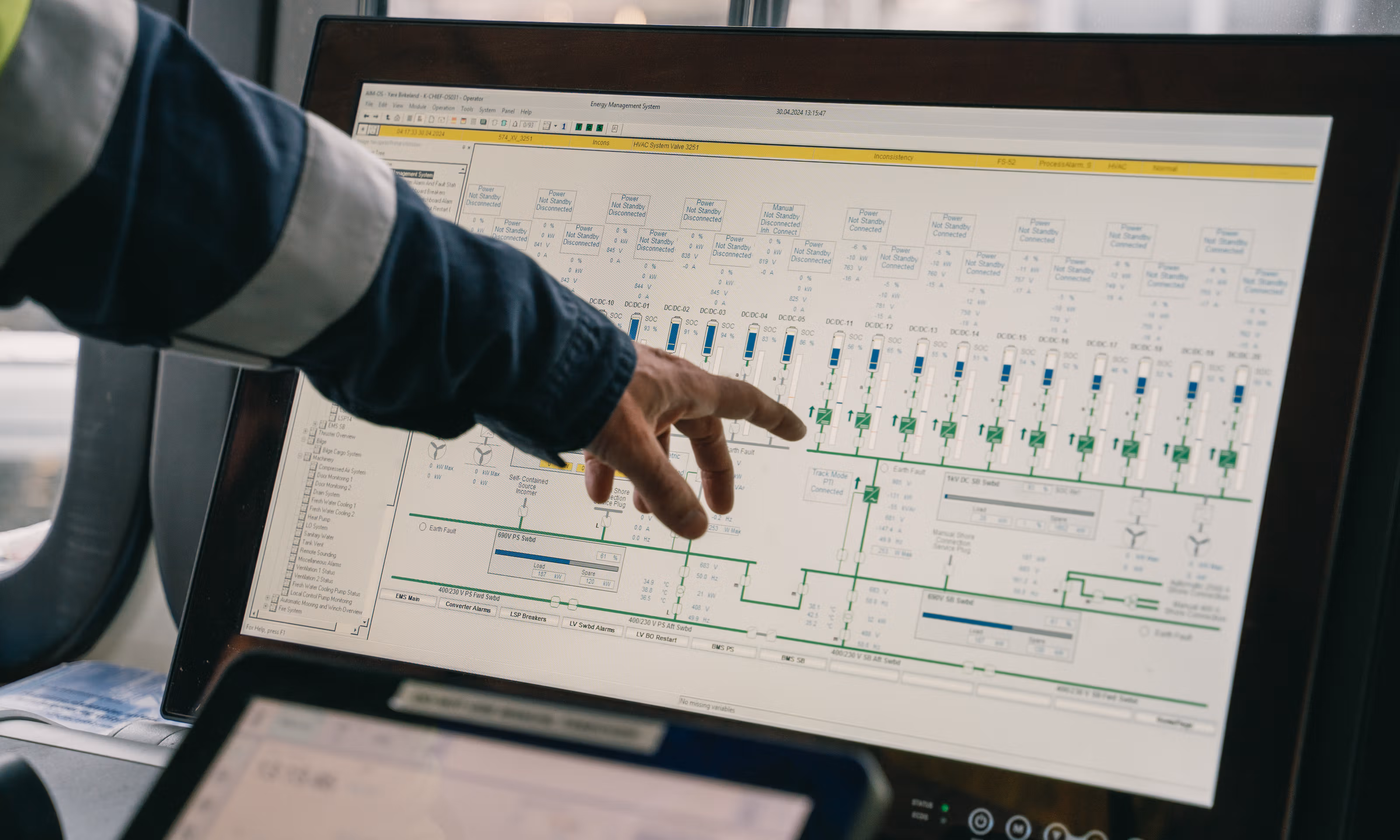 En hånd peker på en skjer ombord på den elektriske båten Yara Birkeland.