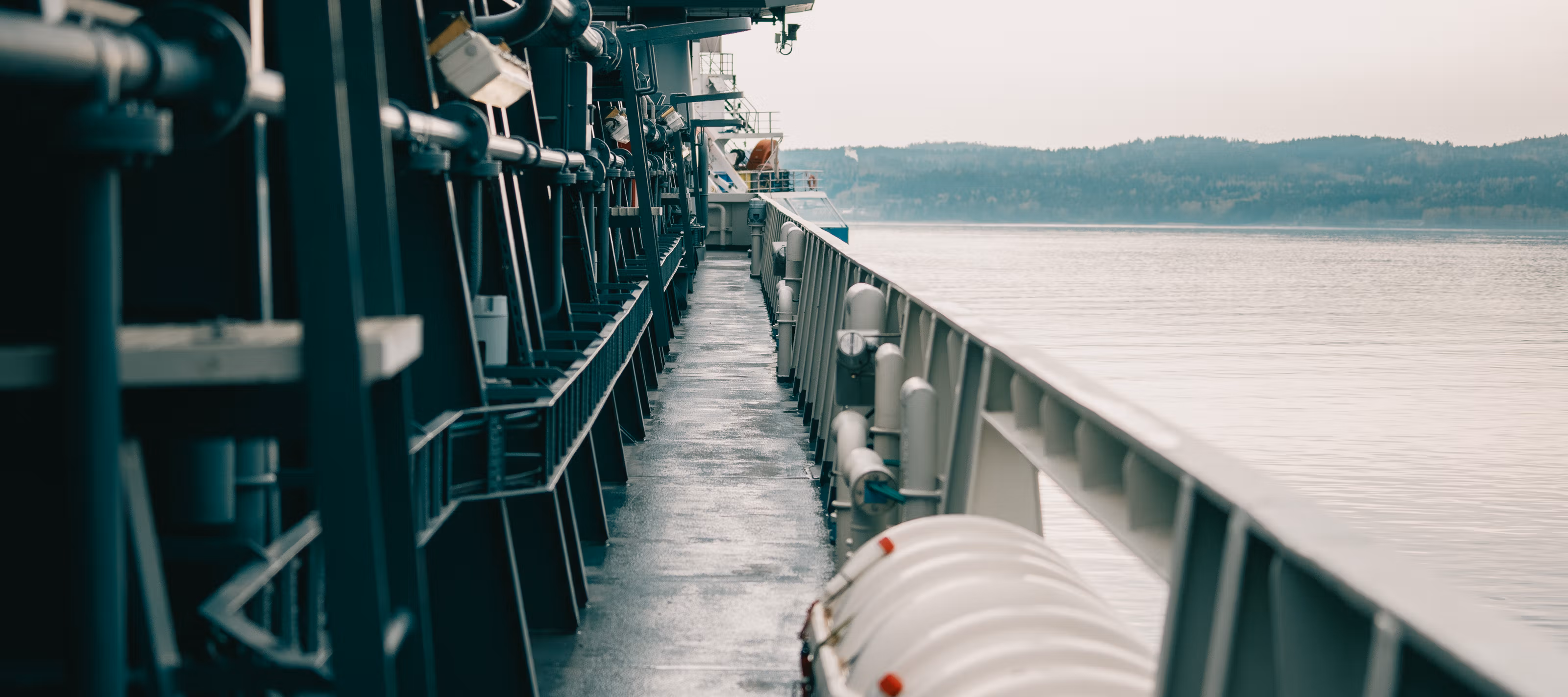 Et fartøy ute på fjorden med åser i bakgrunnen.
