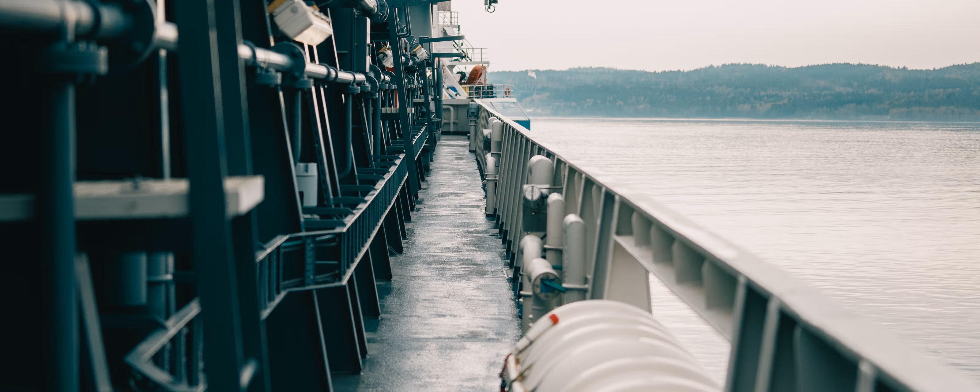 Et fartøy ute på fjorden med åser i bakgrunnen.