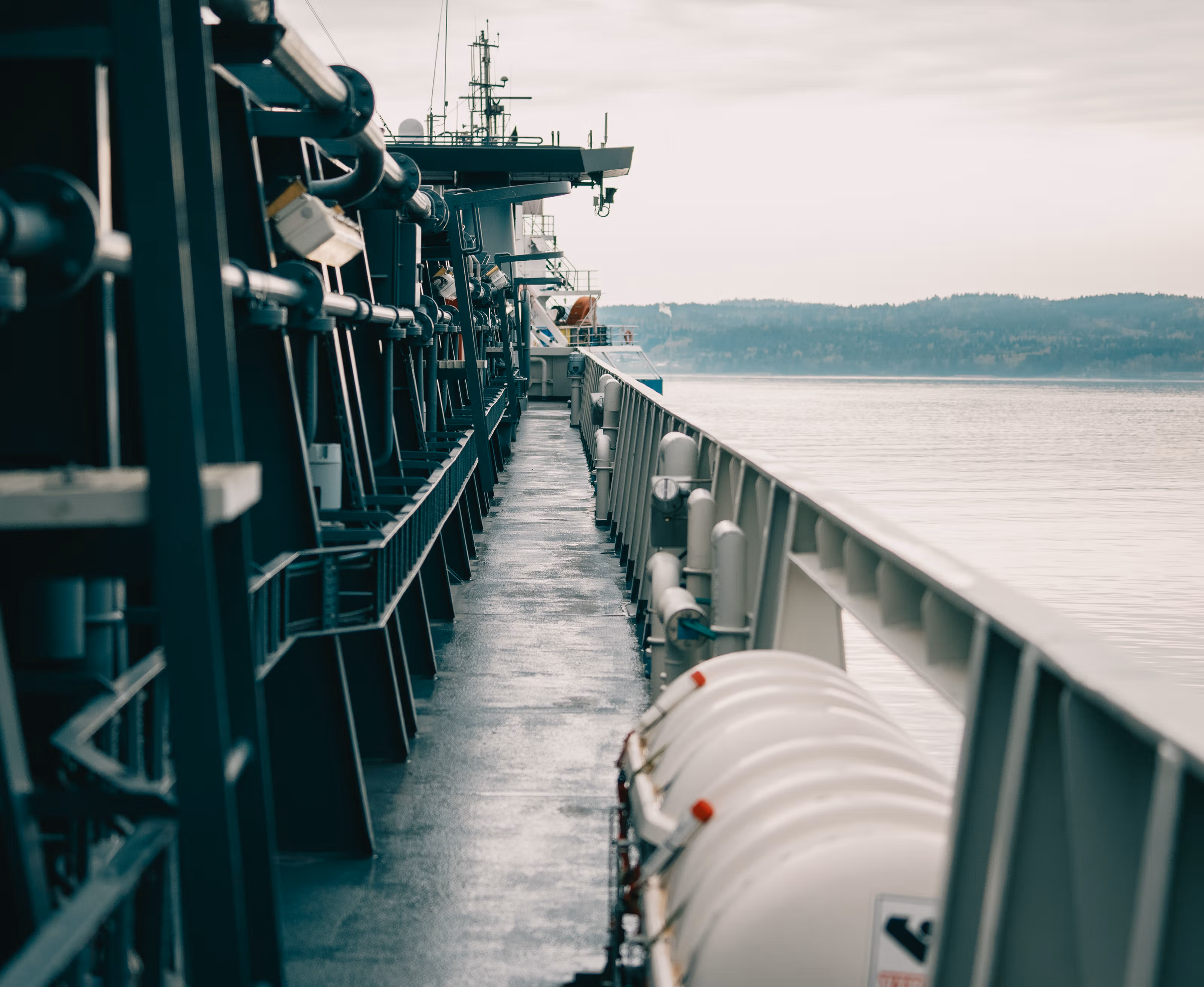Et fartøy ute på fjorden med åser i bakgrunnen.